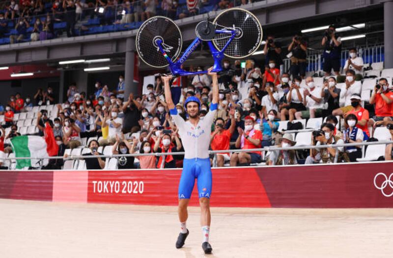 Filippo Ganna of Team Italy lifts his bike to celebrate winning a gold medal after setting a new world record during the men's team pursuit finals.
