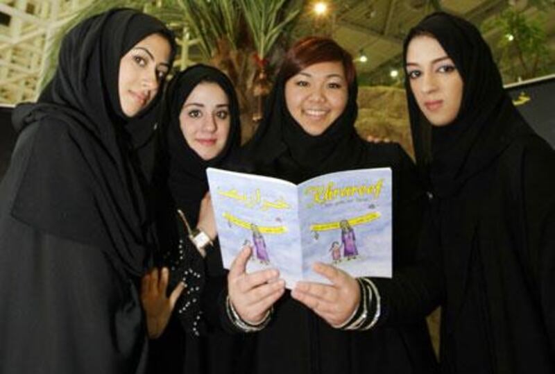 From left, Atheer bin Shaker, Raisa al Zarouni, Sarah Ahrari and Abeer al Ali with the book they have compiled for a school project.