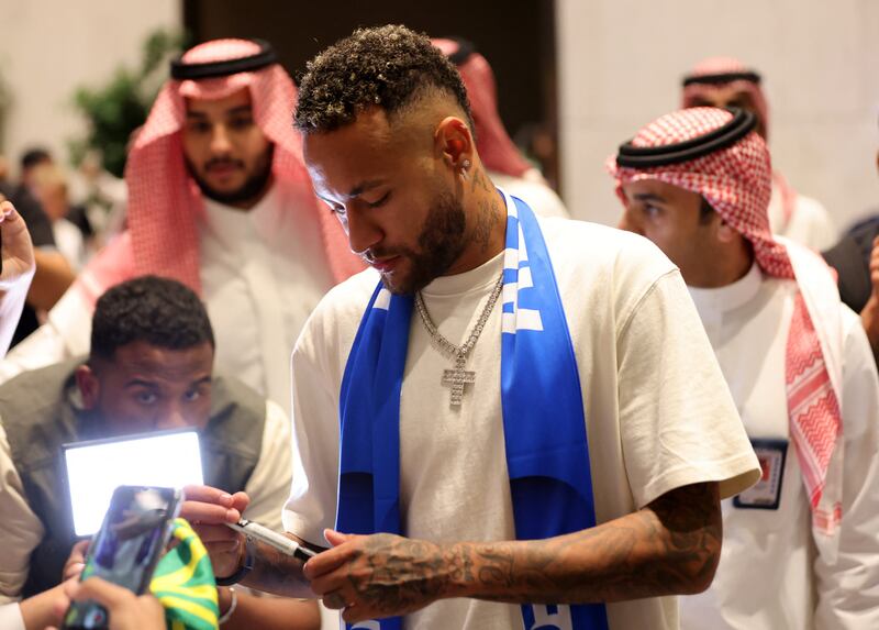 Al Hilal's new signing Neymar signs autographs upon arrival in Riyadh. Reuters