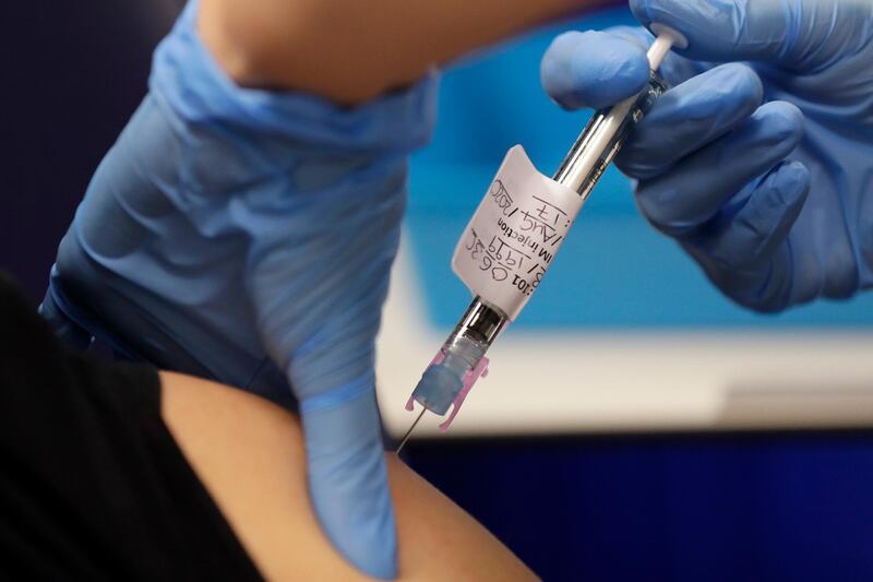 FILE - In this file photo dated Wednesday, Aug. 5, 2020, a volunteer is injected with a trial vaccine as part of an Imperial College vaccine trial, at a clinic in London.  Britain is preparing to revise its laws to allow the emergency use of any effective coronavirus vaccine before it is fully licensed but only if the shots meet required safety and quality standards, according to a government statement Friday Aug. 28, 2020. (AP Photo/Kirsty Wigglesworth, FILE)