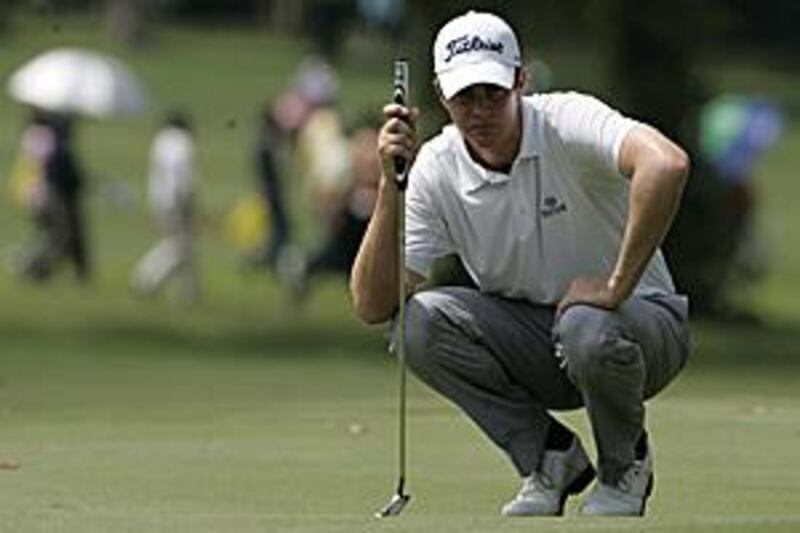 Adam Blyth eyes up a putt on the fourth green during the third round of the Malaysian Open.