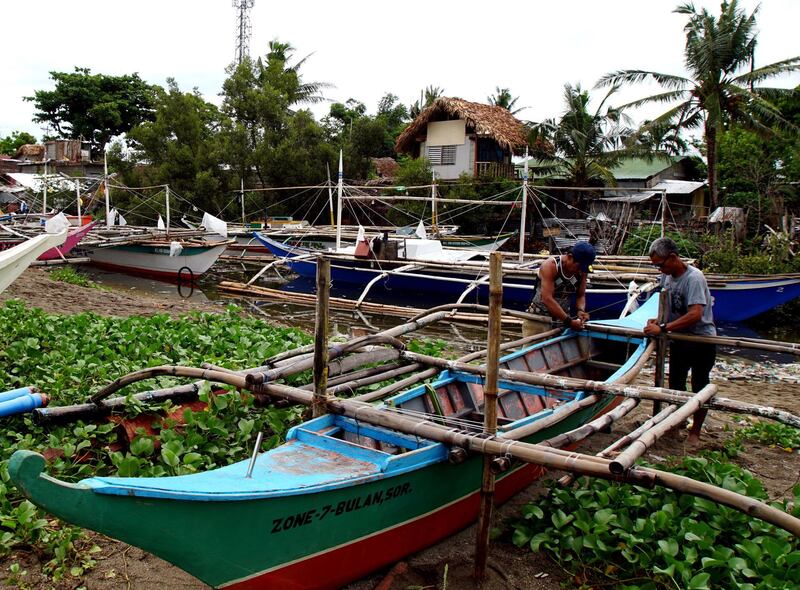 Filipino villagers secure a fishing boat in anticipation of an approaching typhoon in the coastal town of Bulan, Sorsogon province, Philippines.  EPA