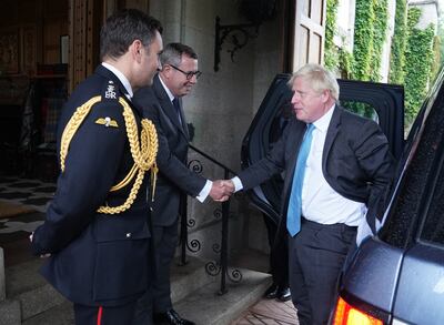 Boris Johnson is greeted by the Queen Elizabeth II's equerry Lt Col Tom White and her private secretary Sir Edward Young as he arrives to formally resign as prime minister at Balmoral Castle in Scotland on Tuesday. Getty Images