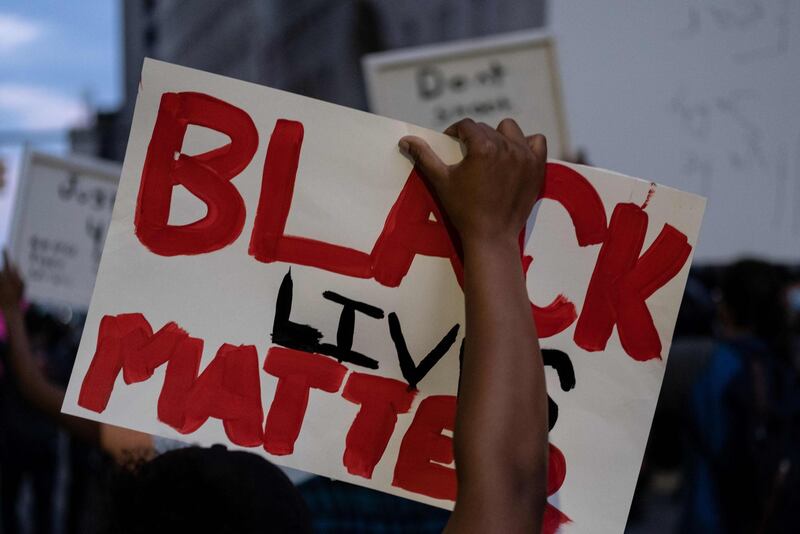 A person holds up a placard that reads, 'Black lives matter' during a protest in the city of Detroit, Michigan, on May 29, 2020, during a demonstration over the death of George Floyd, a black man who died after a white policeman knelt on his neck for several minutes.    Violent protests erupted across the United States late on May 29, over the death of a handcuffed black man in police custody, with murder charges laid against the arresting Minneapolis officer failing to quell boiling anger. / AFP / SETH HERALD
