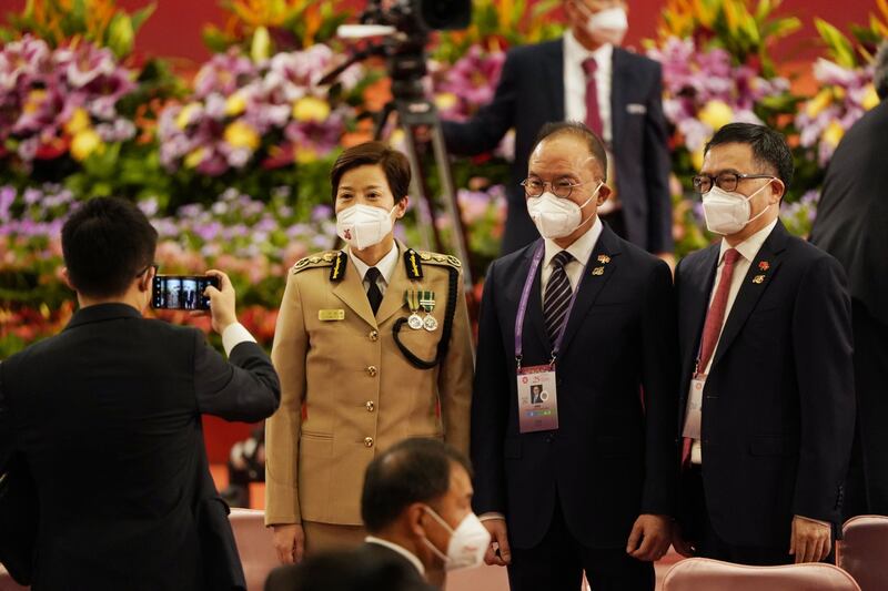 Erick Tsang, Hong Kong's Secretary for Constitutional and Mainland Affairs, centre, and his wife Louise Ho Pui-shan, commissioner of customs and excise, left, at the swearing-in ceremony. Bloomberg