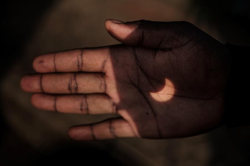 A partial solar eclipse is projected on a Kenyan man's hand through binoculars in Nairobi. AFP