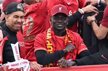 Liverpool's Brazilian striker Roberto Firmino (L) and Liverpool's Senegalese striker Sadio Mane celebrate from an open-top bus during a parade through the streets of Liverpool in north-west England on May 29, 2022, after winning the 2021-22 League Cup and FA Cup.  - Despite the disappointment of losing to real Madrid in the final of the UEAF Champions League, Klopp has called on Liverpool fans to take to the streets of the city on Sunday when they parade the League Cup and FA Cup.  (Photo by Oli SCARFF  /  AFP)