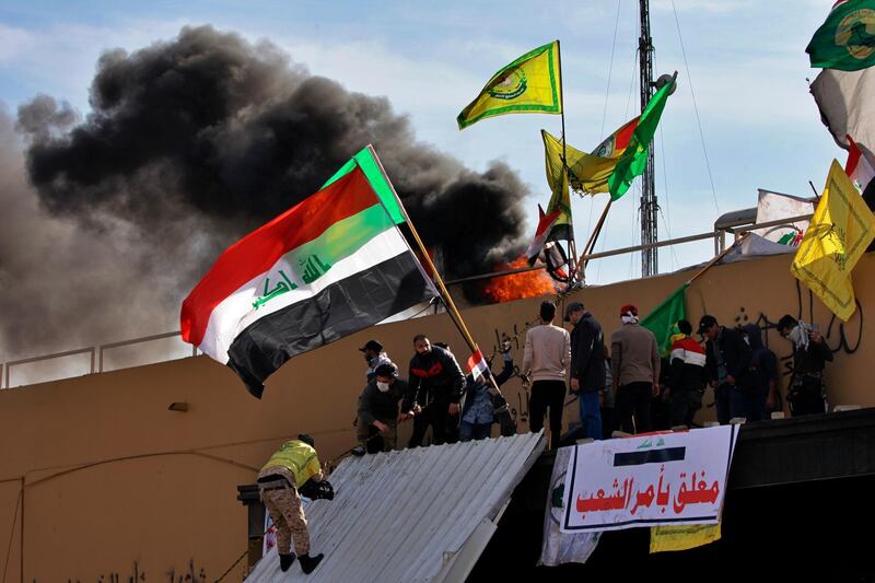 Pro-Iranian militiamen and their supporters light a fire during the demonstration. AP Photo