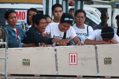 Eva (2nd L), mother of Filipina worker Joanna Demafelis whose body was found inside a freezer in Kuwait, cries in front of the wooden casket containing her daughter's body shortly after its arrival from Manila at Iloilo International Airport in Iloilo province, central Philippines, on February 17, 2018.
The body of Filipina worker Joanna Demafelis arrived back in Manila from Kuwait to a tearful welcome on February 16, just days after Philippines President Rodrigo Duterte barred his nationals from working in the Gulf state. / AFP PHOTO / -