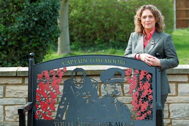 Hannah Ingram-Moore, Captain Sir Tom Moore's daughter, next to a commemorative bench outside the family home. Reuters