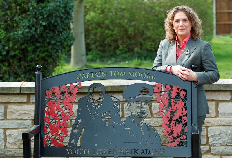 Hannah Ingram-Moore, Captain Tom's daughter, poses for a portrait next to a commemorative bench outside the family home as she launches 'Captain Tom 100'  - a new fundraising initiative to celebrate the joy and hope her father brought to people, in Marston Moretaine, near Milton Keynes, Britain March 31, 2021. Picture taken March 31 2021. REUTERS/Andrew Boyers