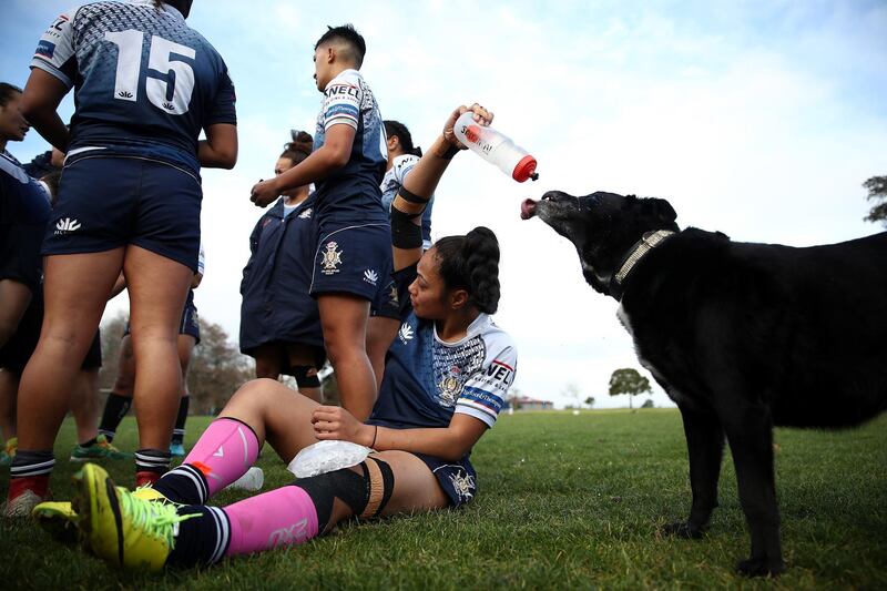Corina Nanai gives her dog a drink during half time in the women's rugby match between Manurewa and College Rifles at Mountford Park in Auckland, New Zealand. Phil Walter/Getty Images