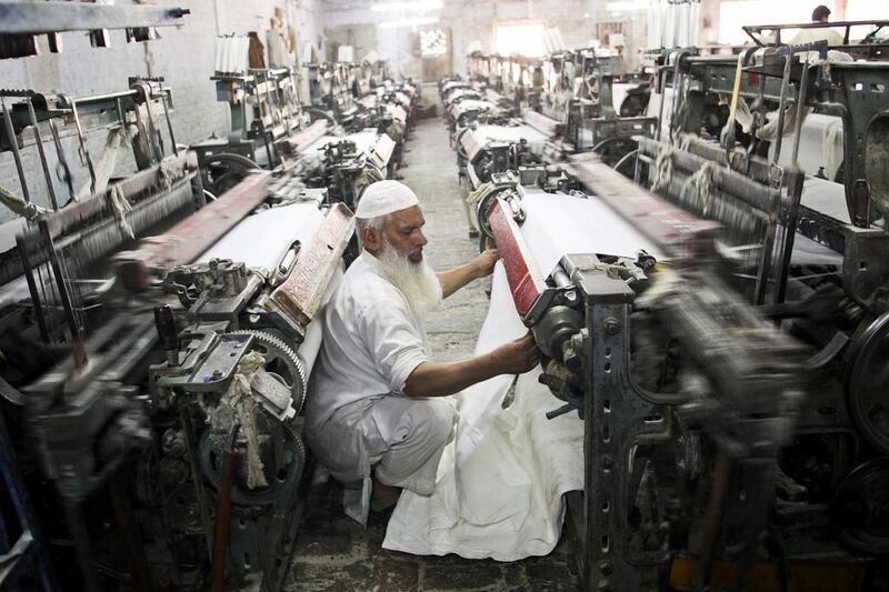 A worker inspects cotton cloth on a loom in a textile factory in the district of Faisalabad, Punjab, Pakistan. Textile and leather products, ethanol and plastics are the key sectors that will benefit from Pakistan winning key EU tariff status. Asad Zaidi / Bloomberg