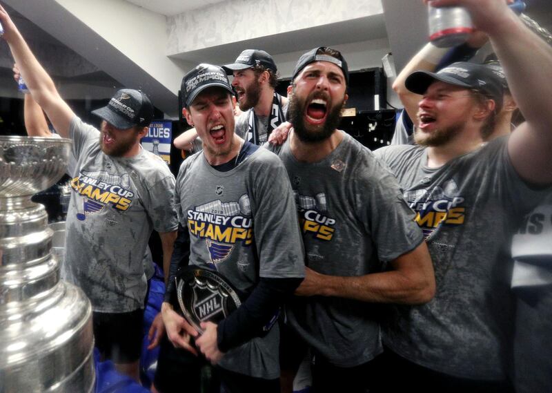 St. Louis Blues from left Brayden Schenn, Jordan Binnington, Joel Edmundson, Robert Bortuzzo and Vladimir Tarasenko, of Russia, right, celebrate with the Stanley Cup in the locker room after defeating the Boston Bruins in Game 7 of the NHL Stanley Cup Final in Boston.  AP
