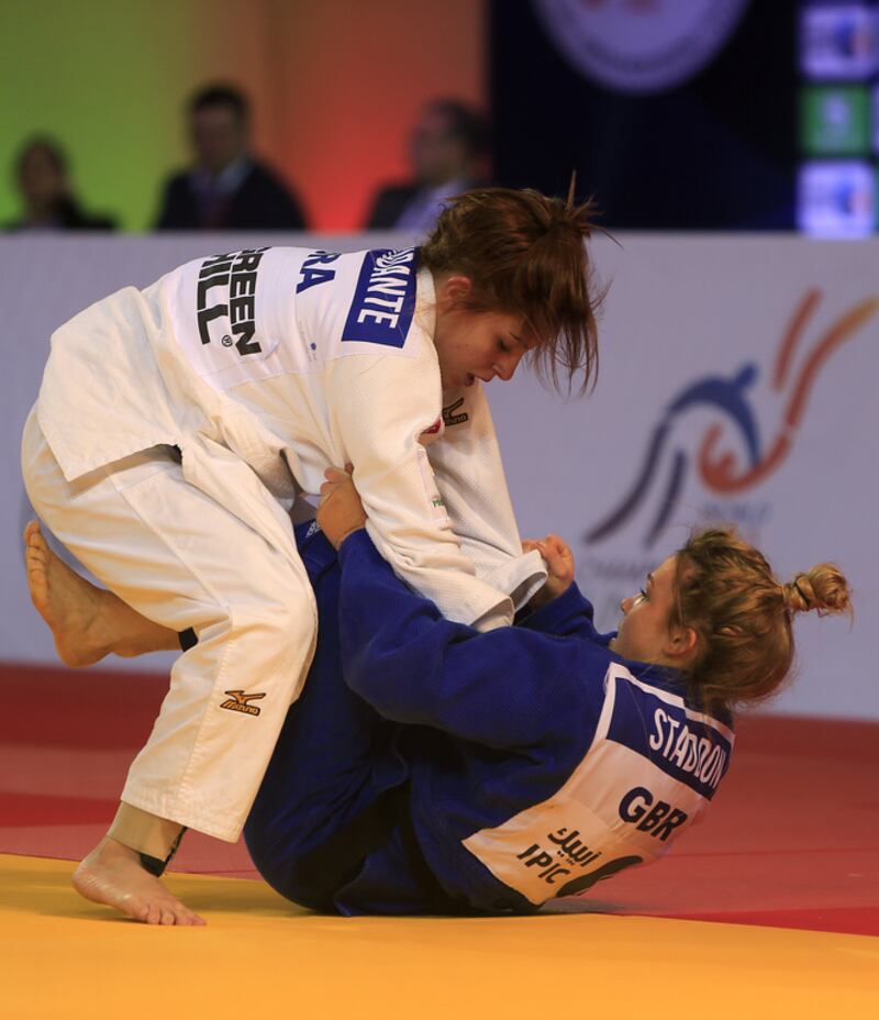 Kelly Staddon, in blue from Great Britain, fights with Nathalia Mercadante from Brazil on the opening day of the International Judo Federation (IJF) Junior World Championships, which started at the Ipic Arena at the Zayed Sports City in Abu Dhabi on Friday. Ravindranath K / The National