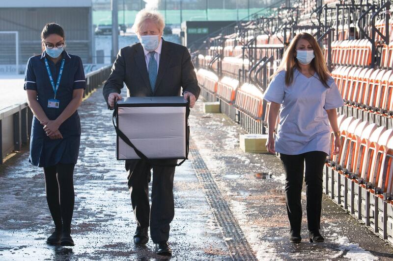 LONDON, ENGLAND - JANUARY 25: British Prime Minister Boris Johnson carries doses of the Oxford/AstraZeneca coronavirus vaccine for mobile distribution at Barnet FC's ground, The Hive, north London, which is being used as a coronavirus vaccination centre on January 25, 2021 in London, England. Government figures show that 6.3 million people across the UK have received their first dose of the coronavirus vaccine, as 32 more vaccination centres open across England. (Photo by Stefan Rousseau - WPA Pool/Getty Images)