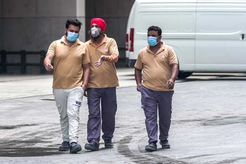 Abu Dhabi, United Arab Emirates, April 16, 2020.  Workers with face masks have a chat while walking at downtown Abu Dhabi during the Coronavirus epidemic.Victor Besa / The NationalSection:  NAFor:  Standalone/Stock Images