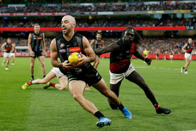 Steele Sidebottom of the Magpies runs with the ball against the Essendon Bombers. Getty