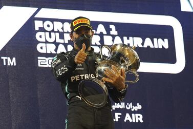 epa09103436 British Formula One driver Lewis Hamilton of Mercedes-AMG Petronas celebrates with the trophy on the podium after winning the 2021 Formula One Grand Prix of Bahrain at the Sakhir circuit near Manama, Bahrain, 28 March 2021. EPA/VALDRIN XHEMAJ
