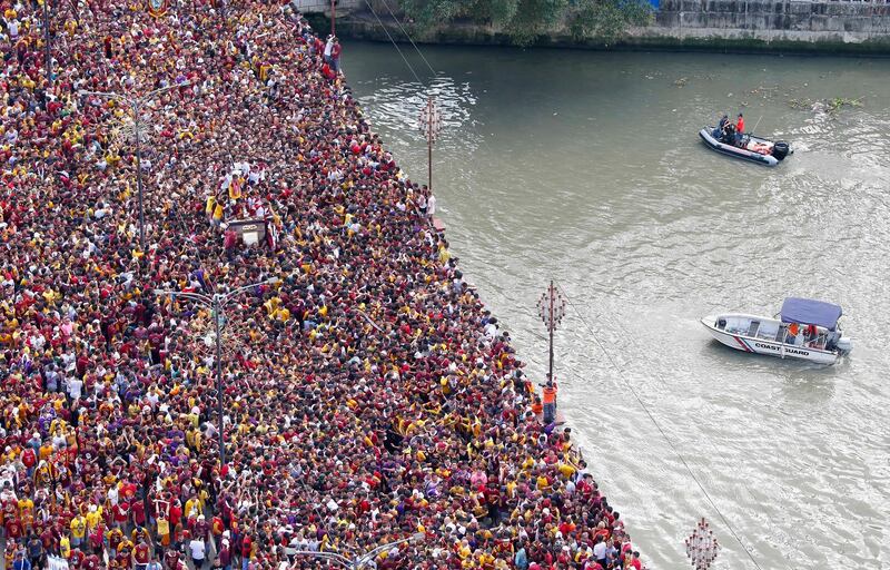 Coastguard vessels keep a close watch as thousands of Roman Catholic devotees cross the bridge in a raucous procession of the Black Nazarene. AP Photo