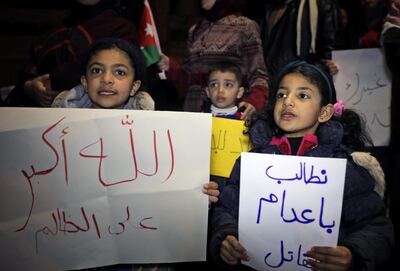 Children hold placards as they take part in a sit-in near the New Zealand Consulate against shooting at the Al Noor mosque in Christchurch, in Amman, Jordan, March 15, 2019. The placards read: "We demand the execution of the murderer", "God is greater than the unjust". REUTERS/Muhammad Hamed