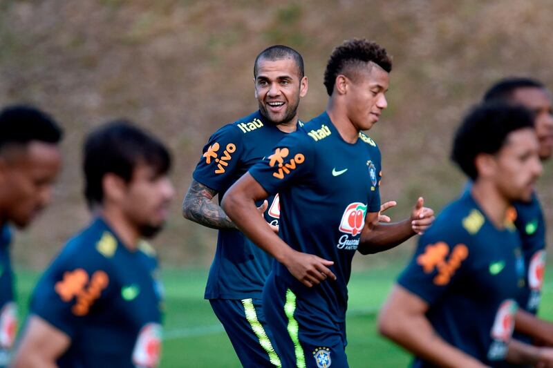 Brazil captain Dani Alves, centre, smiles as he and his teammates jog around the pitch. AFP