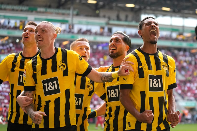 Borussia Dortmund players celebrate after Dortmund's Sebastien Haller, right, scored his side's second goal during the German Bundesliga soccer match between FC Augsburg and Borussia Dortmund at the WWK Arena in Augsburg, Germany, Sunday, May 21, 2023.  (AP Photo / Matthias Schrader)