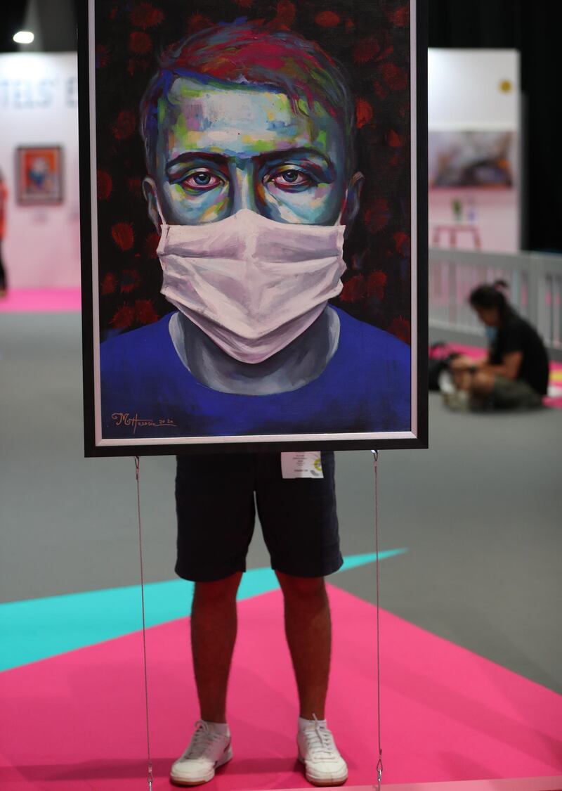 A visitor stands behind the artwork 'Quarantine' by Syrian Artist Mohammed Hussein at the World Art Dubai fair.  EPA