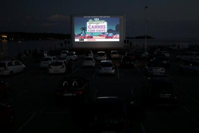 FILE PHOTO: People sit in their cars to watch the movie "E.T. the Extra-Terrestrial" by Steven Spielberg at a drive-in cinema at la Pointe Croisette, during the coronavirus disease (COVID-19) outbreak, in Cannes, France May 20, 2020. REUTERS/Eric Gaillard/File Photo