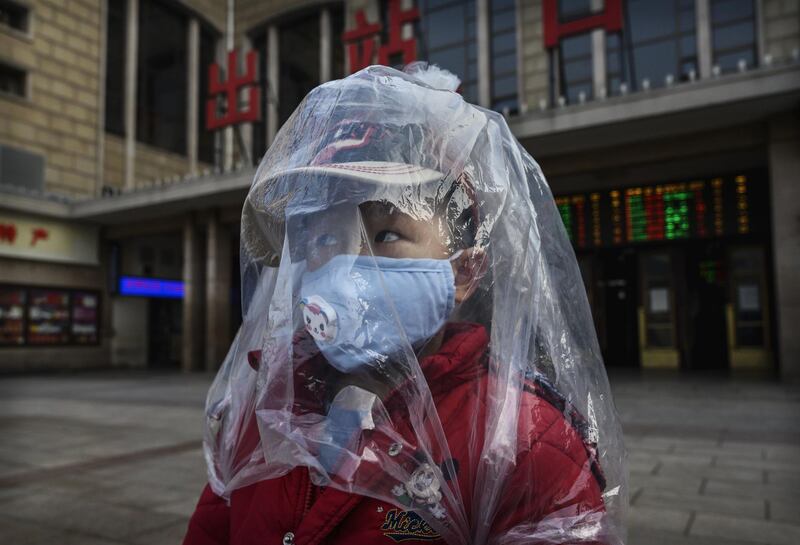 A Chinese boy is covered in a plastic bag for protection as he arrives from a train at Beijing Station,China.  Getty