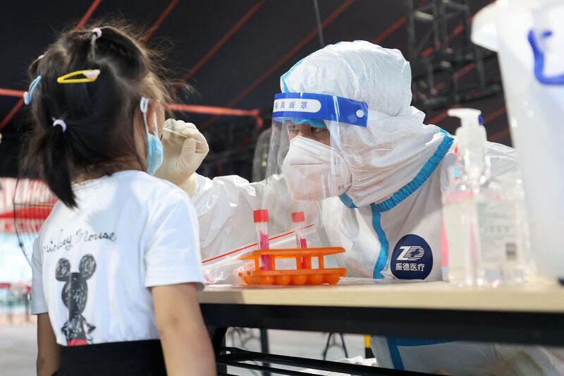 A health worker carries out a Covid-19 test in Xiamen, in China's eastern Fujian province. More tracking systems are now in place to detect virus outbreaks. AFP