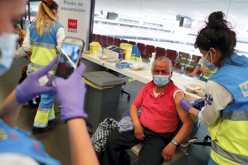 An elderly man receives an injection with AstraZeneca's COVID-19 vaccine at a vaccination centre, at the Wanda Metropolitano stadium, in Madrid, Spain, March 31, 2021. REUTERS/Susana Vera