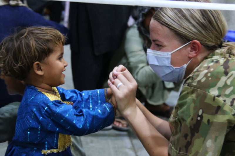 A National Guard soldier welcomes a young child to Camp Buehring, Kuwait. Photo: US Department of Defence