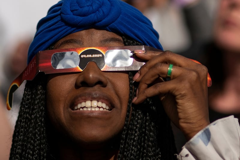A woman looks through a viewing device at the eclipse on the observation deck of Edge at Hudson Yards in New York. Reuters