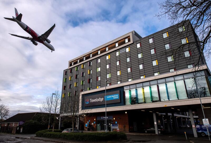 LONDON, ENGLAND - JANUARY 28: An airplane flies over a Travelodge Hotel as it comes in to land at Heathrow Airport on January 28, 2021 in London, England. Arriving travellers from 22 "red list" countries including South Africa, South American countries and Portugal, will now need to quarantine in hotel rooms upon arrival to the UK. The measures have been introduced to prevent new strains of the covid-19 virus from taking hold here. Other countries have adopted this policy with travellers paying for their accommodation in designated hotels and are delivered meals during the quarantine period. (Photo by Chris J Ratcliffe/Getty Images)