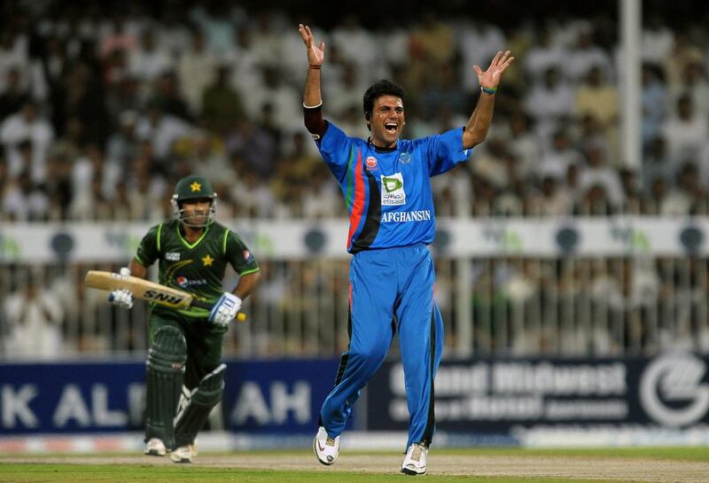 Afghanistan's cricketer Dawlat Zadran (R) celebrates after dismissing Pakistan's cricketer Asad Shafiq (back) during the first One Day International (ODI) match between Pakistan and Afghanistan at the Sharjah Cricket Stadium in Sharjah on February 10, 2012. AFP PHOTO/ LAKRUWAN WANNIARACHCHI