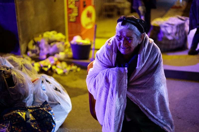 An Armenian woman from Nagorno-Karabakh warms herself near a tent camp after arriving in Goris. AP