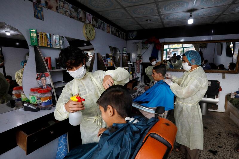 Hairdressers wearing protective suits work at a barber shop ahead of Muslim festival of Eid al-Fitr, which marks the end of the holy fasting month of Ramadan, amid the ongoing coronavirus COVID-19 pandemic in Sanaa, Yemen.  EPA