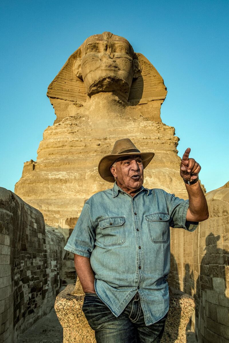 Zahi Hawass, Egyptian archaeologist and former antiquities minister, stands before the Great Sphinx of Giza during a lecture with a tourist group on ancient Egyptian history, at the Giza Necropolis on the southeastern outskirts of the capital on November 20, 2019. - The 72-year-old dubbed "the Egyptian Indiana Jones" revels in his reputation as an indefatigable yet controversial figure in the enigmatic world of Egyptology. Having appeared in dozens of documentaries about ancient Egypt, Hawass himself is a star attraction for a luxury archaeological tour organised by an operator based in Poland. He was head of Egypt's Supreme Council of Antiquities from 2002 to 2011 and then briefly minister of antiquities in early 2011, before leaving in a haze of corruption allegations along with other Mubarak allies. (Photo by Khaled DESOUKI / AFP)