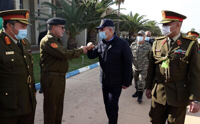 Turkey's Defense Minister Hulusi Akar, centre, and other top Turkish military commanders, rear, greet Libyan commanders, in Tripoli, Libya, Saturday, Dec, 26, 2020. Akar arrived in Tripoli Saturday, where they were meeting with their allies, Libya's UN-backed Government of National Accord, according to the Turkish Defence Ministry.(Turkish Defense Ministry via AP, Pool )