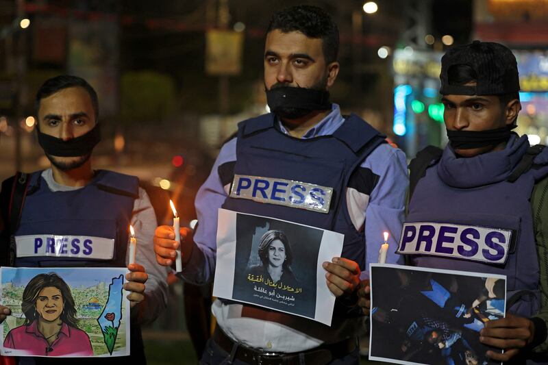 Journalists in the southern Gaza Strip take part in a candlelight vigil to condemn the killing. AFP