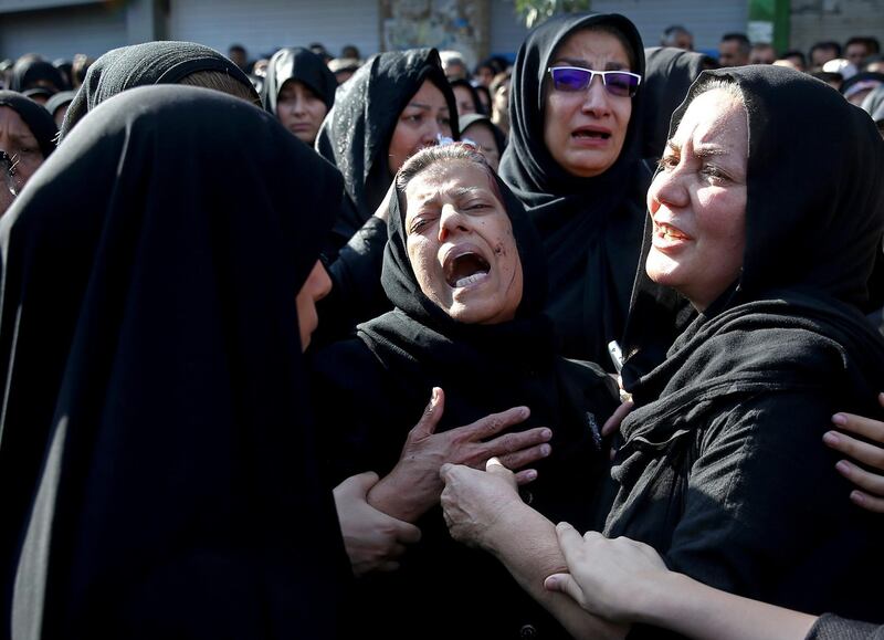 FILE - In this file photo dated Monday, Sept. 24, 2018, families of victims of Saturday's terror attack on a military parade in the southwestern city of Ahvaz, that killed 25 people mourn at a mass funeral ceremony, in Ahvaz, Iran.  A Norwegian citizen of Iranian descent was arrested Oct. 21, 2018, on suspicion of helping an unspecified Iranian intelligence service "to act in Denmarkâ€ against the ASMLA, according to Danish security service chief Finn Borch Andersen and Tehran has blamed the Arab Struggle Movement for the Liberation of Ahwaz (ASMLA) for a terror attack on a military parade in Ahvaz on Sept. 22 that left at least 25 people dead. (AP Photo/Ebrahim Noroozi, FILE)