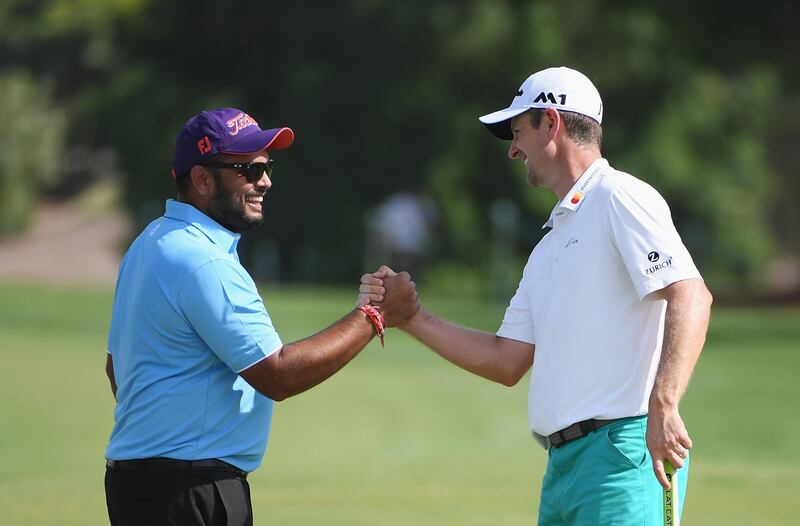 Justin Rose of England shakes hands with Ashish Bhutani during the Pro-Am.  Ross Kinnaird / Getty Images