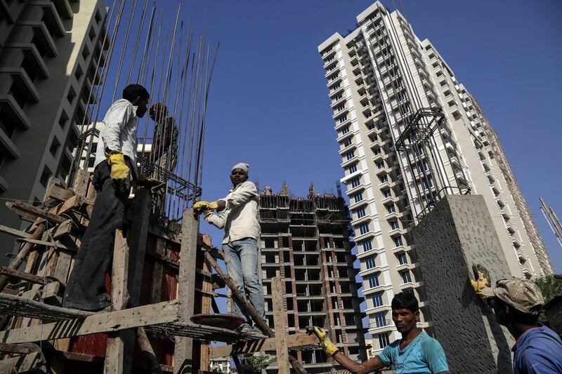 Indian labourers work at a new building under construction in Mumbai. Divyakant Solanki / EPA
