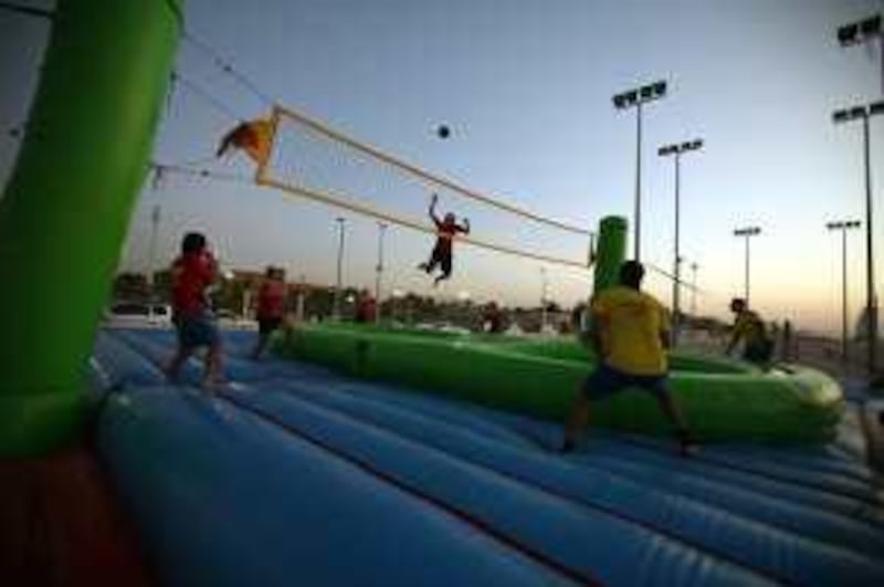 DUBAI, UNITED ARAB EMIRATES - November 26:  Players from Brazil (in yellow) and the Netherlands (in red) play bossaball, a new sport which started in Brazil played on an inflatable court with a trampoline to bossa music, at the beach in Dubai on November 26, 2009.  (Randi Sokoloff / The National)  For News story by Tim Brooks *** Local Caption ***  RS006-112609-BOSSABALL.jpg