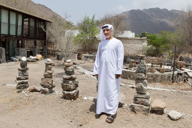 MADHA, OMAN, AUGUST 11, 2015. Abdullah Al Saadi stands in front of one of his rock installation experiments outside his studio. Photo: Reem Mohammed / The National *** Local Caption ***  RM_20150811_SAADI_023.JPG