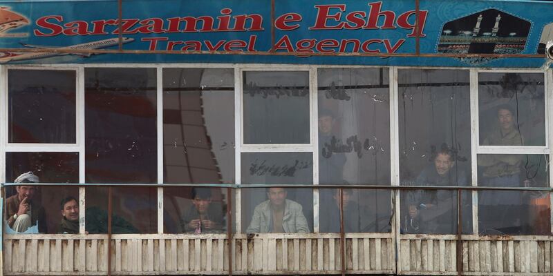 Afghans look from the window of a shop after an attack in Kabul, Afghanistan. AP Photo