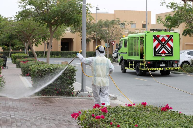 DUBAI, UNITED ARAB EMIRATES , April 11 – 2020 :- Dubai Municipality workers disinfecting the streets in Al Furjan area in Dubai. Dubai is conducting 24 hours sterilisation programme across all areas and communities in the Emirate and told residents to stay at home. UAE government told residents to wear face mask and gloves all the times outside the home whether they are showing symptoms of Covid-19 or not. (Pawan Singh/The National) For News/Online/Instagram/Standalone