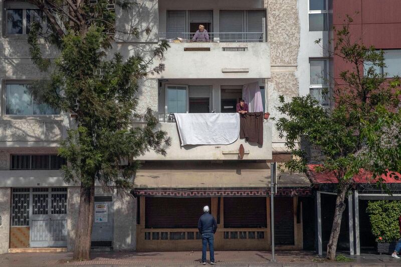 Neighbours have a conversation from their balconies during a health state of emergency and home confinement orders, in Rabat, Morocco. AP Photo
