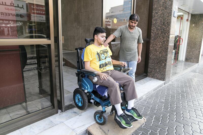 DUBAI, UNITED ARAB EMIRATES - OCT 5:

As there is no access in his building, Sharan Anil, has his household helper help him by putting a wood block infront of the entrance of his building in Deira.

(Photo by Reem Mohammed/The National)

Reporter: RAMOLA TALWAR
Section: NA